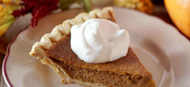 close up photo of pumpkin pie with whipped cream